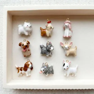 Macro view of nine different cute cartoon dog jewelry charms arranged in a grid