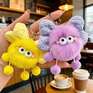 Due adorabili portachiavi mostriciattoli di peluche con fiocchi, in giallo e viola, soffici.
