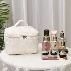 Large white shell quilted cosmetic bag with top handle for professional travel organization