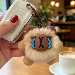 Primo piano di un portachiavi a forma di orsetto di peluche marrone su una chiave auto