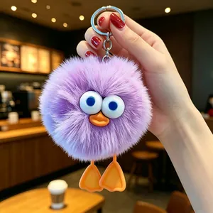 Primo piano di un portachiavi mostro di peluche viola con grandi occhi e piedi d'anatra.