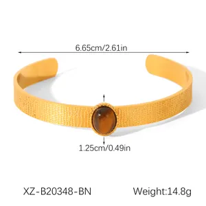 Vista detallada del brazalete de acero dorado con piedra ojo de tigre y dimensiones