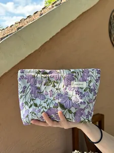 Close-up detail of a portable purple floral embroidery cosmetic bag for travel storage