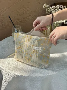 Detailed usage view of a floral embroidered makeup bag with large storage capacity