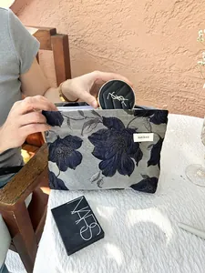 Detail of a floral embroidered makeup bag showing its large capacity and elegant texture