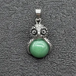 Dettaglio di un ciondolo a forma di gufo in argento con pietra naturale verde scuro