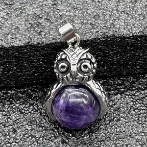 Dettaglio ravvicinato di un ciondolo a gufo in argento con pietra naturale viola
