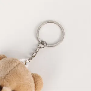 High-quality close-up of a cute brown plush bear keychain featuring a durable metal ring