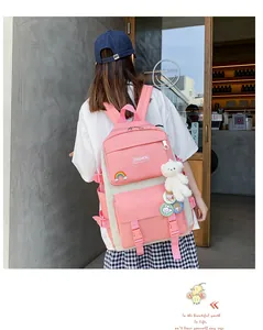Vista posteriore di uno zaino rosa in stile coreano con ciondoli su una modella.
