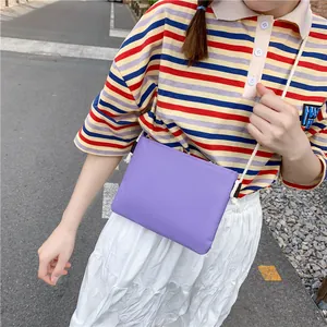 Primo piano di una borsa a tracolla in tela viola, parte di un set di borse per la scuola.