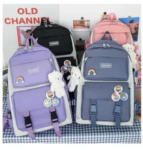 Dettaglio di zaini scolastici colorati con simpatici ciondoli a forma di orso.