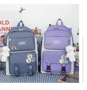 Due eleganti zaini per la scuola in blu e viola con simpatici portachiavi a orsetto e spille.