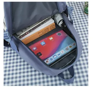 Vista dettagliata dell'interno di un capiente zaino blu con tablet e vari libri