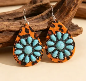 Close-up of teardrop earrings featuring leopard print leather and turquoise sunflower.