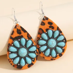 Close-up of Western teardrop earrings with leopard print and turquoise flower detail