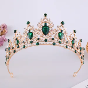 Dettaglio di un'elegante tiara nuziale dorata con gemme di cristallo verde a forma di goccia d'acqua