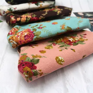 Detailansicht von Vintage-Canvas-Brieftaschen mit Rosenmuster auf weißem Hintergrund.