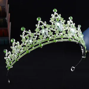 Dettaglio ravvicinato della corona d'argento con strass verdi a forma di goccia
