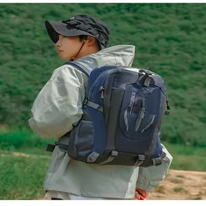 Modell trägt einen dunkelblauen Wanderrucksack in einer Outdoor-Berglandschaft