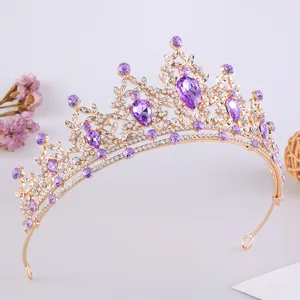 Dettaglio di un'elegante corona da sposa dorata con vivaci cristalli viola a forma di goccia