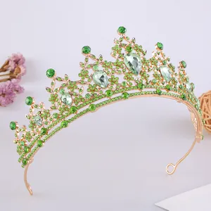 Dettaglio di un elegante diadema dorato con scintillanti cristalli e strass verdi