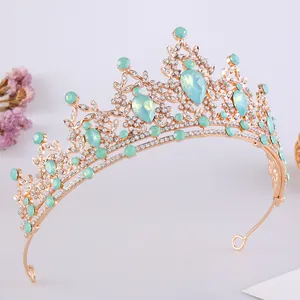 Vista dettagliata della lavorazione della tiara dorata con strass e pietre verdi