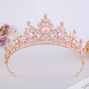 Dettaglio di una tiara da sposa in oro rosa con cristalli rosa a goccia e piccoli strass.