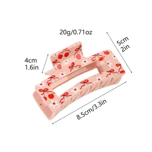 Detail showing measurements of pink hair claw clip with cherry and bow print pattern