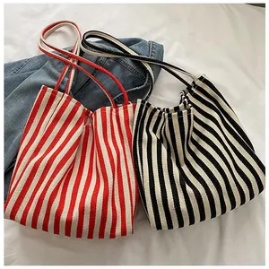 Hochwertige Detailansicht minimalistischer gestreifter Canvas-Taschen in Rot und Schwarz.