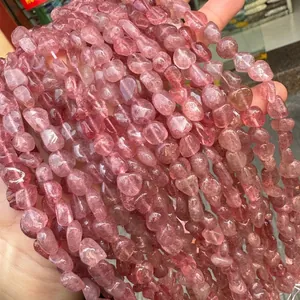 Gros plan de perles irrégulières en quartz fraise rouge naturel pour la création de bijoux.