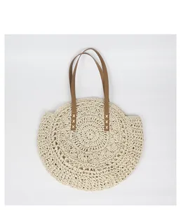 Handmade Bohemian round straw bag with brown faux leather straps for summer beach trips