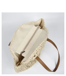 Close-up detail view of woven straw tote bag interior with zipper pocket and lining