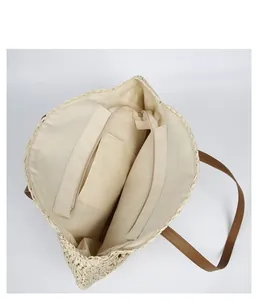 Interior detail of a round straw beach bag showing zipper closure and inner lining.