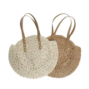 Two bohemian round straw woven beach tote bags in cream and tan colors on white background.