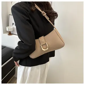 Detailed view of the stylish khaki underarm bag with a golden D-buckle.