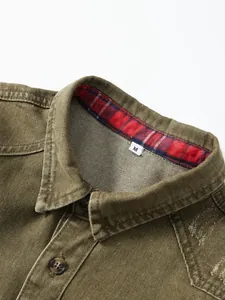 Detailansicht eines armeegrünen Jeanshemdkragens mit rotem Karo-Futter und Etikett