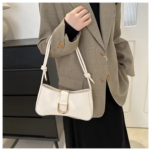 Close-up lifestyle view of a chic French style white underarm bag with a gold D-buckle