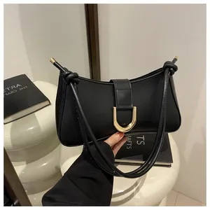 Close-up of stylish black French niche design underarm bag with elegant gold U-buckle