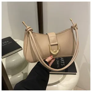 Detail view of a beige chic underarm bag with elegant gold U-buckle and knotted strap