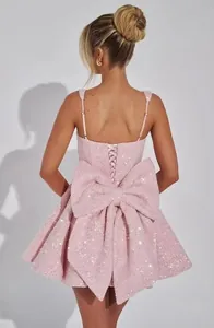 Vista posteriore di un mini abito rosa con paillettes, maxi fiocco e stringhe