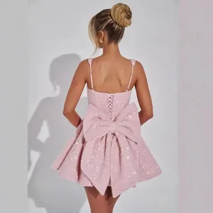 Elegante mini abito da cocktail con paillettes rosa, fiocco posteriore e allacciatura.