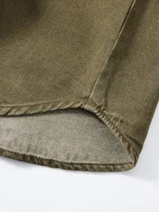 Nahaufnahme des Saums eines olivgrünen Workwear-Denimhemdes mit robuster Twill-Textur.