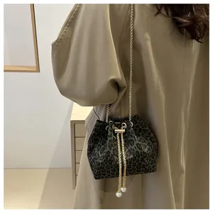 Bolso bombonera chic con estampado de leopardo, cadena dorada y detalles de perlas
