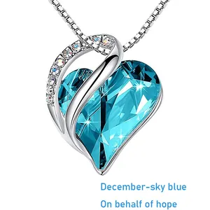 Nahaufnahme einer herzförmigen Halskette mit himmelblauem Kristall für den Dezember