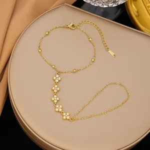 Elegante catena da mano in acciaio inossidabile dorato con quadrifogli in strass