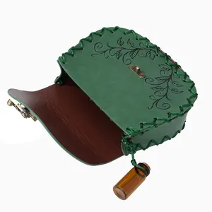 Detailed interior view of a green steampunk leather pouch with leaf vine pattern