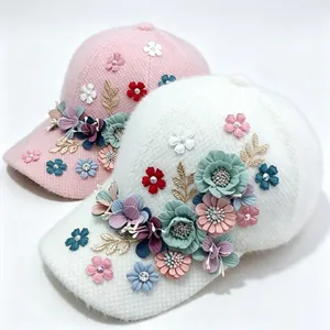Close-up of fuzzy baseball caps with 3D fabric flowers and gold accents.