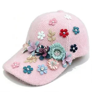 Close-up detail of a pink plush baseball cap featuring 3D floral and rhinestone decor.
