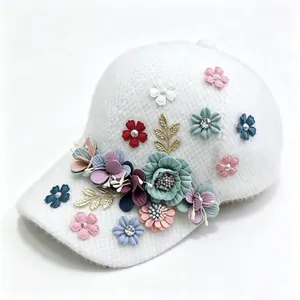 Close-up of a white plush baseball cap with 3D colorful fabric flowers and rhinestones