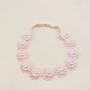 Close-up of pink lace flower headband featuring elegant pearl accents for baby girls